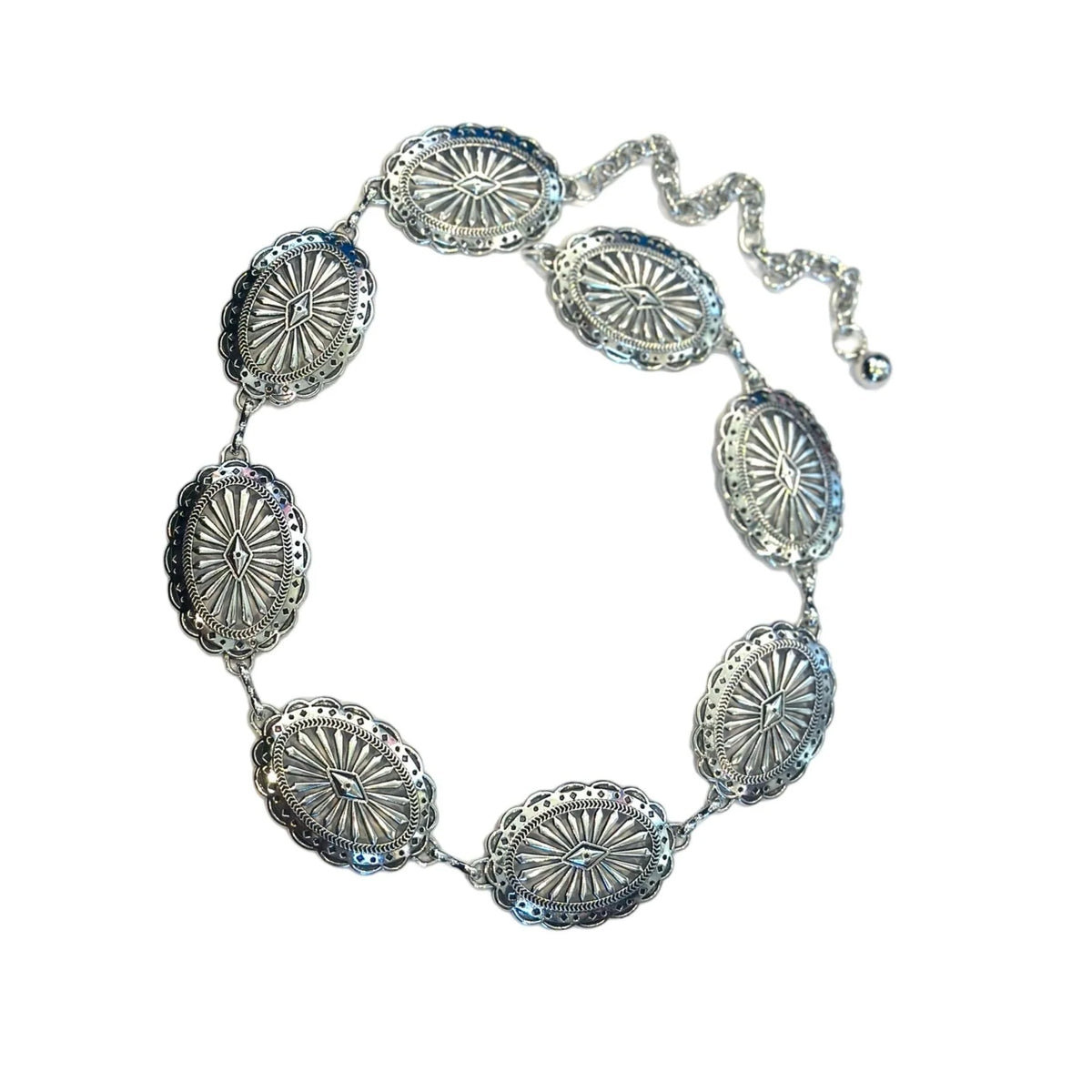 Close-up of oval concho belt styled with black bottoms