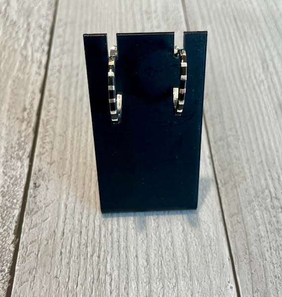 Sterling silver and black onyx hoop earrings displayed on a jewelry stand