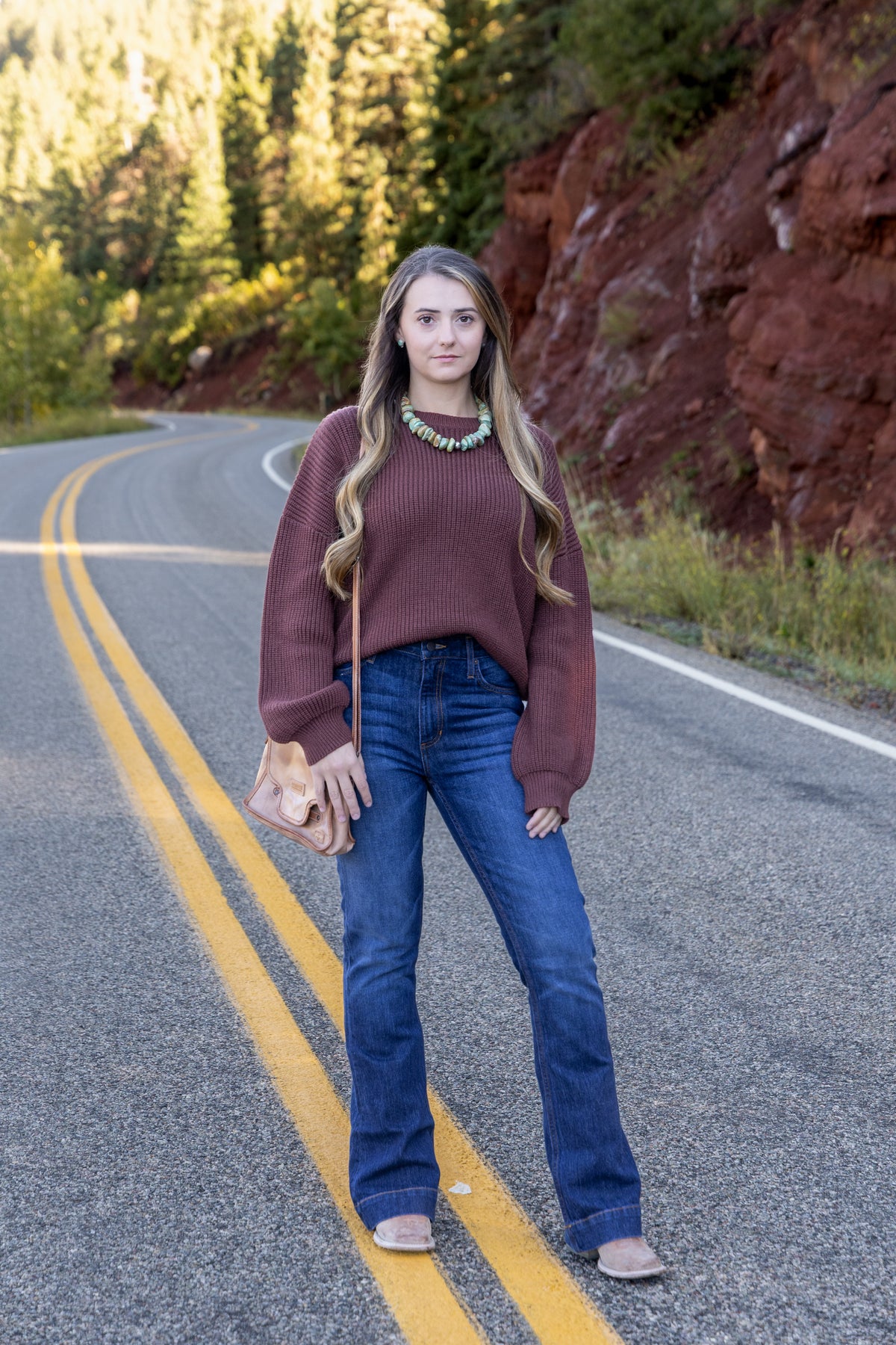 Model wearing the Mikarose oversized ribbed knit sweater in Maple with jeans, front view