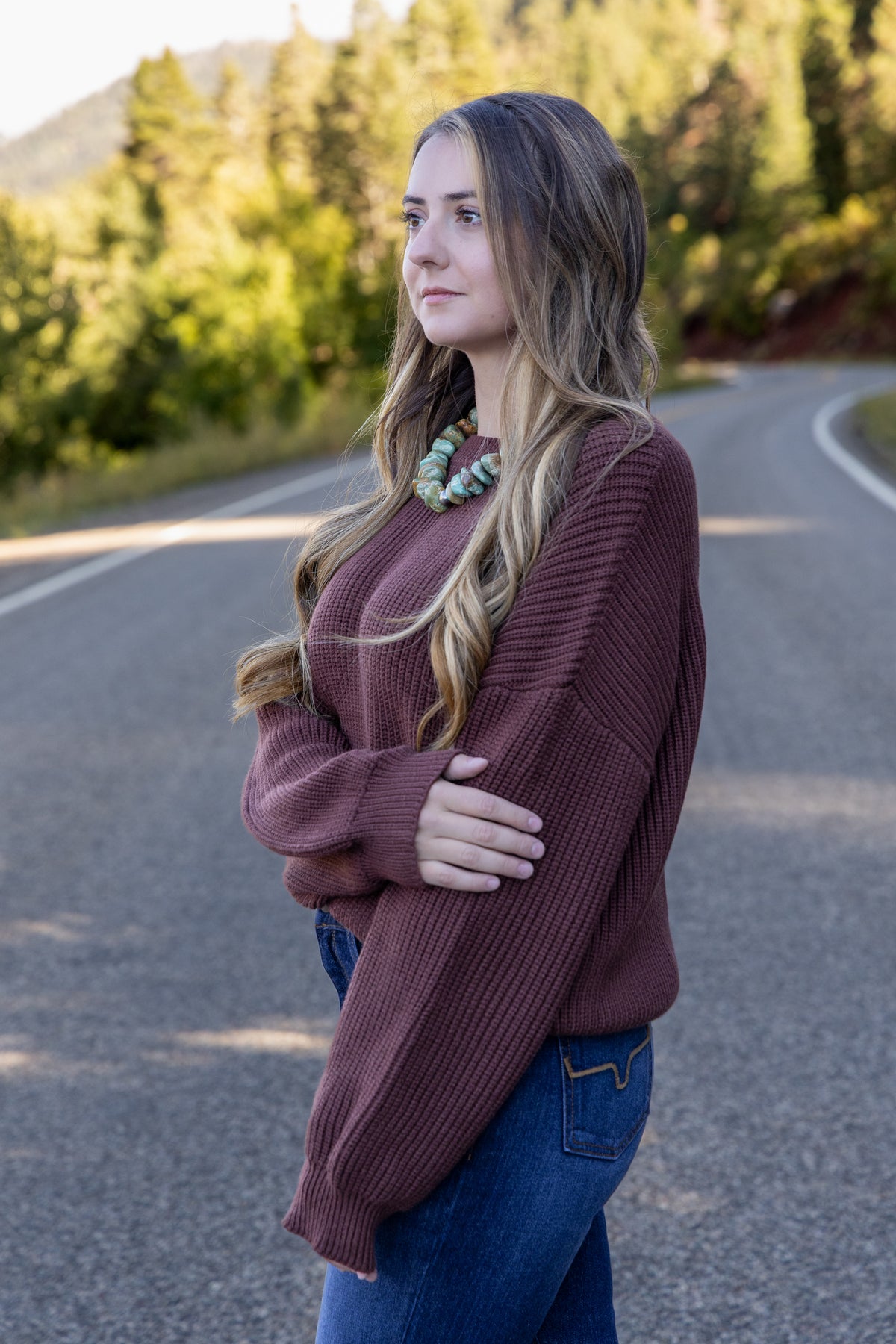 Model wearing the Mikarose oversized ribbed knit sweater in Maple, side view