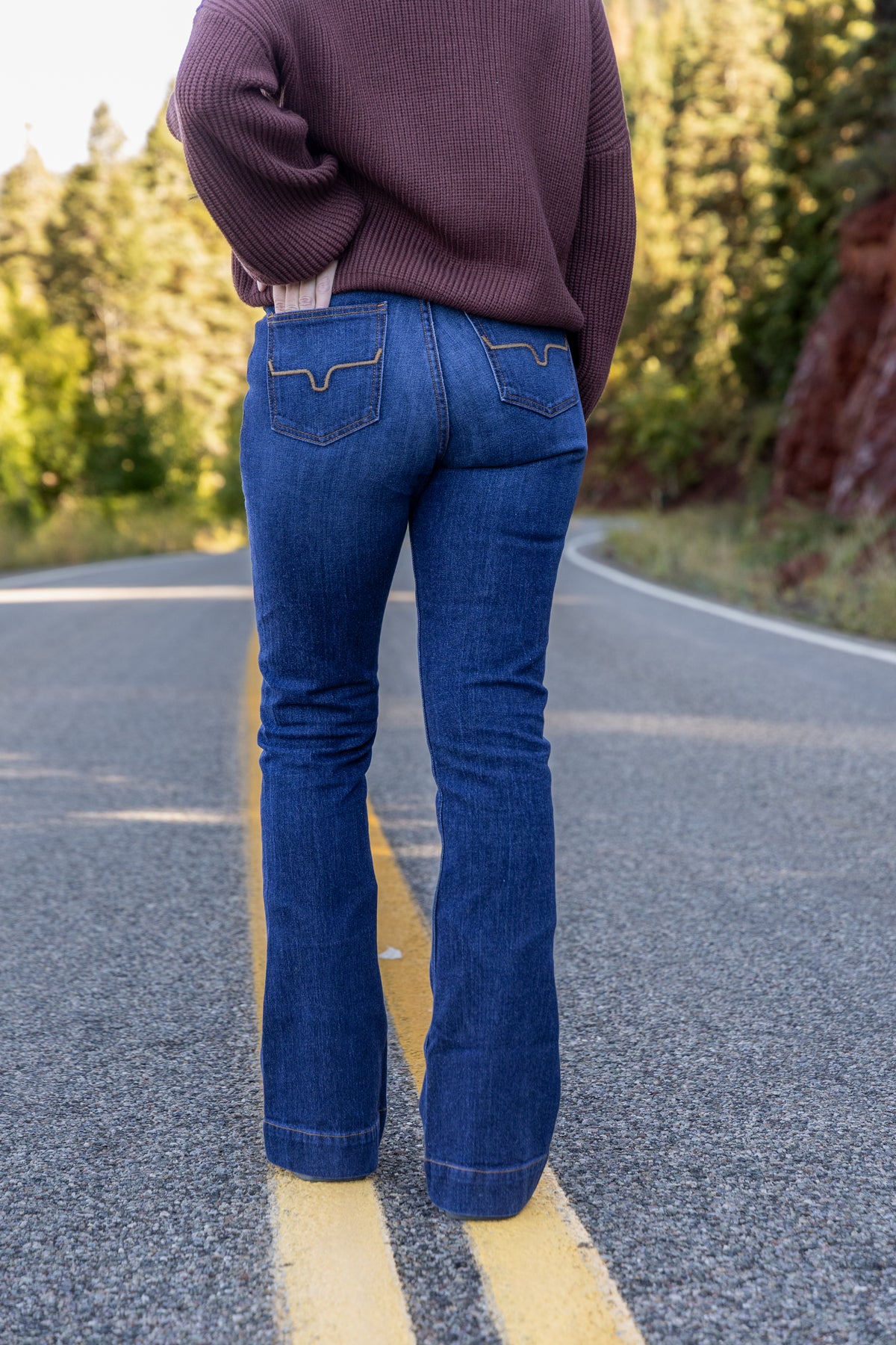 Back view of the Mikarose oversized ribbed knit sweater in Maple styled with jeans
